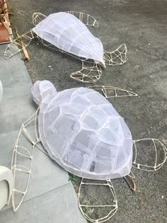 two plastic turtle sculptures sitting on the sidewalk