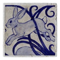 a blue and white tile with an image of a rabbit on it's back