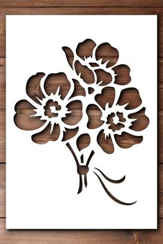 a paper cutout of flowers on a wooden surface