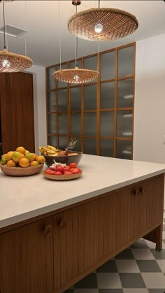 a kitchen counter topped with lots of fruit on top of it's white counter