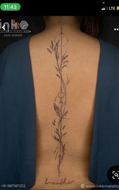 the back of a woman's neck with a flower tattoo on it