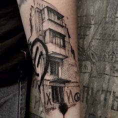 a black and white photo of a building on someone's arm with the word love written below it