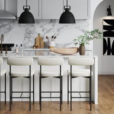 a kitchen with marble counter tops and stools in front of the island, surrounded by black pendant lights