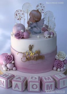 a cake decorated with pink and white icing has an angel figurine on top