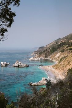 the ocean is blue and clear with lots of rocks on it's shore,