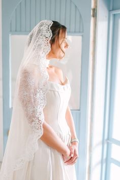 a woman in a white wedding dress and veil