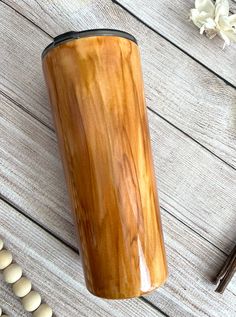 a wooden coffee cup sitting on top of a table next to beans and cinnamons