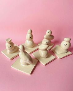 a group of small white figurines sitting on top of a pink tablecloth