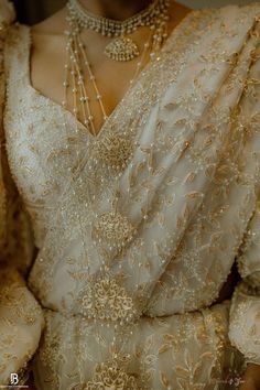 the back of a woman's wedding dress with pearls on it