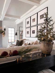 a living room filled with furniture and a christmas tree on top of a coffee table