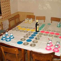 a child sitting at a table with cups and bottles on it, in front of a sign that says mogen die spiel beginen