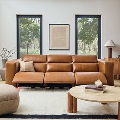 a living room filled with furniture and large windows