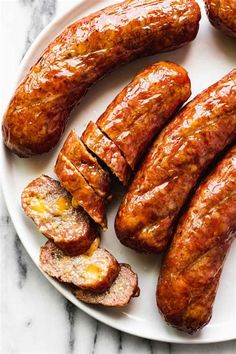 several sausages on a plate with one cut in half