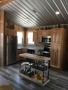 a kitchen with wooden cabinets and stainless steel appliances in the middle of an open floor plan