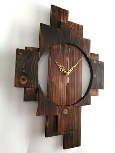 a clock made out of wood with a chain hanging from it's center piece