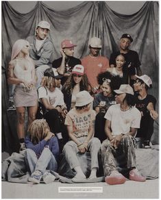 a group of young people sitting next to each other in front of a black curtain