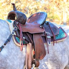 a white horse with saddle on it's back