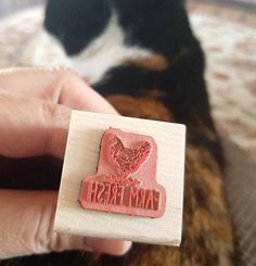 a hand holding a rubber stamp that says farm fresh with a dog in the background