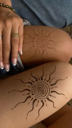 a woman's legs with tattoos on them and her hand resting on the leg