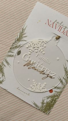 a white christmas ornament on top of a card that says merry naviday