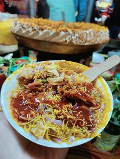 a person holding a plate with food on it in front of other plates full of food