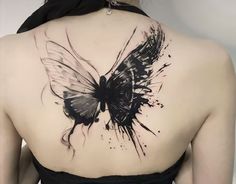 the back of a woman's shoulder with a black and white butterfly tattoo on it