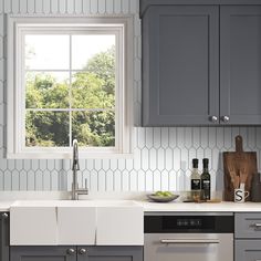 a kitchen with gray cabinets and white counter tops, an open window over the sink