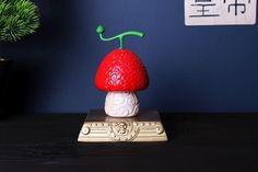 a small red mushroom sitting on top of a wooden table