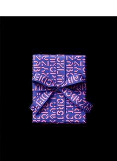 a purple wrapped gift with pink lettering on it