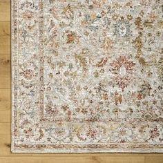 an area rug on a wooden floor with wood floors and white, red, blue, orange and green colors