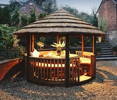 a wooden gazebo sitting on top of a gravel field