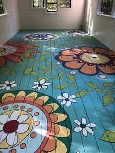 the floor is painted with colorful flowers and leaves on it, as well as an open window