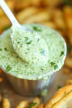 a close up of a spoon with some food in it and green stuff on top