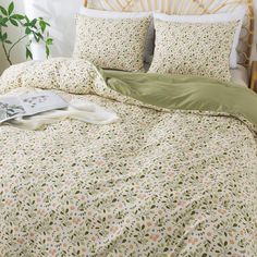 a bed with green sheets and pillows on it