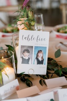 a table with place cards and flowers on it, next to a couple's photo