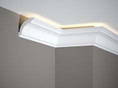 an empty room with white trim on the ceiling and light coming from above it,