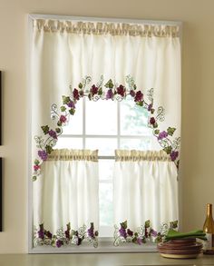 a kitchen window with flowers on the valance