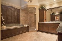 a large bathroom with a walk in shower next to a bathtub and sink area