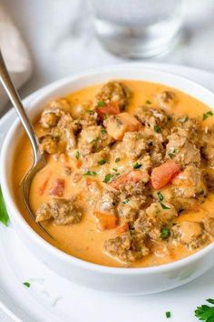 a white bowl filled with meat and vegetable soup