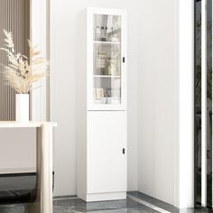 a tall white cabinet sitting next to a window in a room with black and white tile flooring