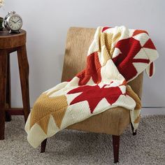 a chair with a blanket on it next to a clock