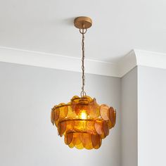 a chandelier hanging from the ceiling in a room with white walls and flooring