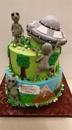 an alien themed birthday cake is on display