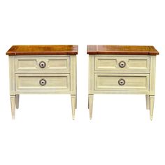 pair of white nightstands with wood top and drawer pulls on legs, side by side