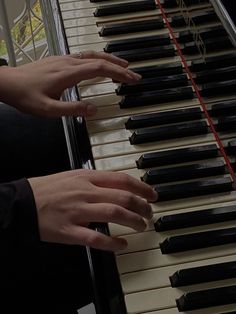 two hands are playing the piano together