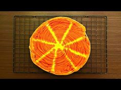 an orange cake sitting on top of a cooling rack