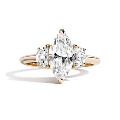 a three stone ring with diamonds on the sides and an oval diamond in the middle