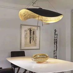 a table with a bowl on it and some lights hanging from the ceiling over it