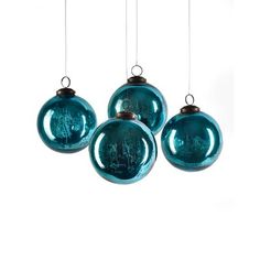 three blue glass ornaments hanging from strings