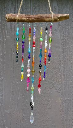 a wind chime hanging from a tree branch with beads and glass beads on it